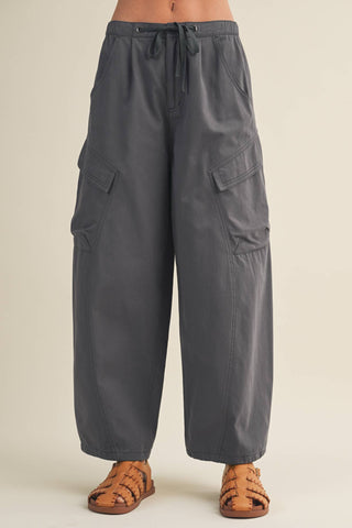 Gray cargo pants worn by a person on a beige background