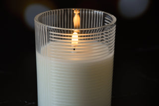 Candle in a glass holder with a blurred dark background