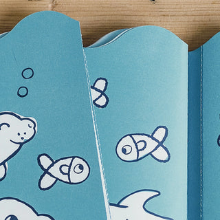 Blue fabric with white fish pattern on a wooden background