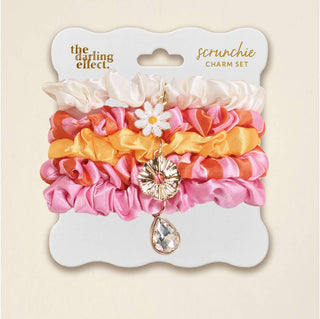 Set of colorful scrunchies with charms on a 'The Darling Effect' packaging.