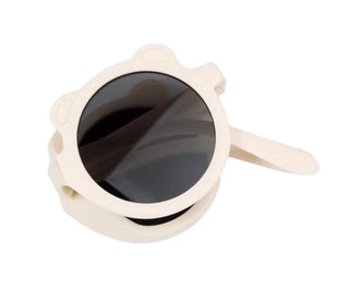Beige sunglasses with black lenses on a white background