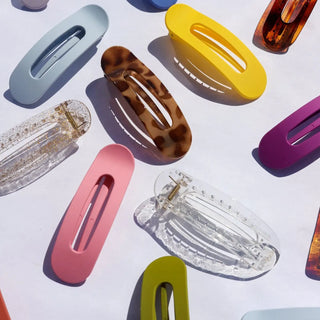 Colorful hair clips arranged on a light background