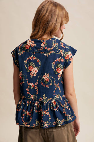 Navy floral top worn by a person on a beige background