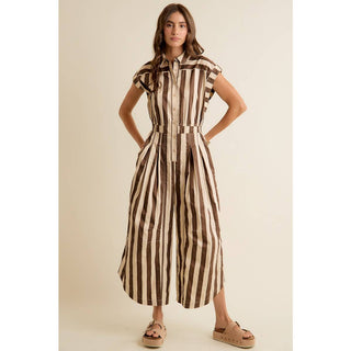 Woman wearing a brown and beige striped dress on a beige background