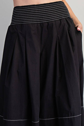 Black skirt with white trim on a gray background