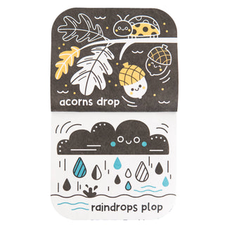 A children's sensory toy set featuring two textured cards with autumn-themed illustrations. The top card is dark brown with white, yellow, and black line drawings of an acorn tree, a ladybug, and acorns, with the text 'acorns drop'.