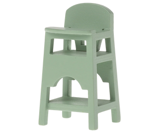 Light green children's high chair on a white background