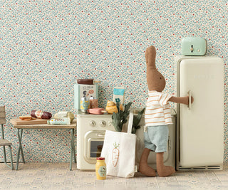 Stuffed animal character in a kitchen setting with a refrigerator and floral wallpaper.