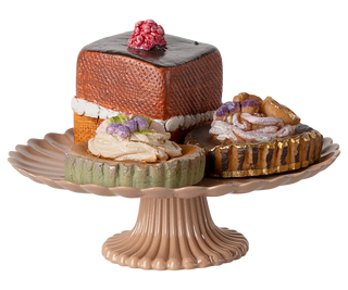 Decorative cake stand with miniature cakes on a white background