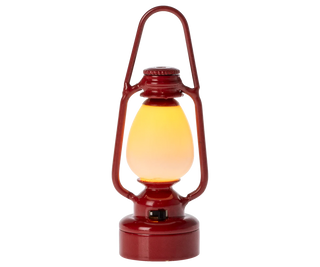 Red lantern with a glowing yellow light on a white background