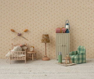 Miniature room setup with furniture and decor on a neutral background