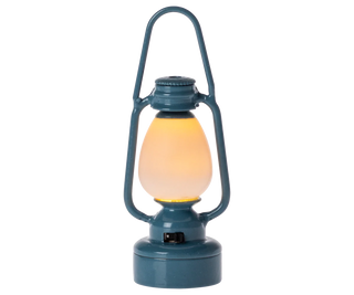 Blue lantern with a glowing yellow light on a white background