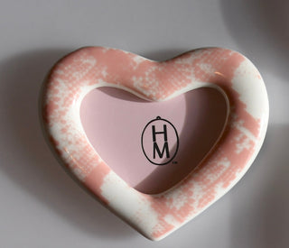 Heart-shaped pink and white frame with 'HM' logo on a gray background