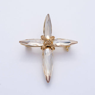 Gold and clear crystal brooch on a light gray background
