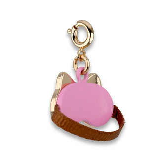 Pink charm with gold accents and brown strap on a white background