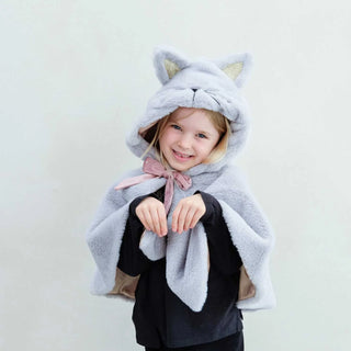 Child wearing a gray cat hooded cloak with ears on a light background