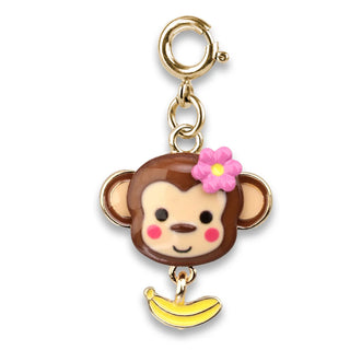 A monkey-shaped charm keychain with a gold-tone clasp, featuring a brown and beige monkey face with a pink flower on its head and a dangling yellow banana.
