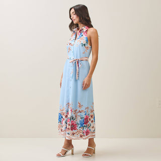 Woman wearing a light blue floral dress on a plain background