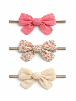 Three colorful bow hair accessories on a white background