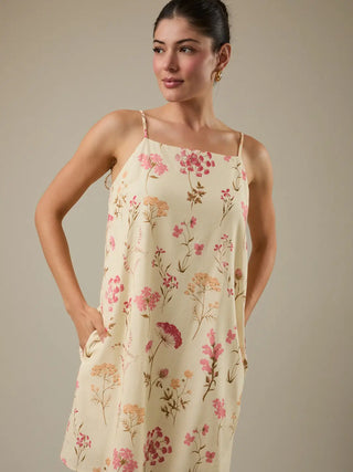 Woman wearing a floral dress against a neutral background