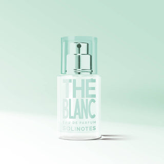 Perfume bottle labeled 'The Blanc' on a light green background