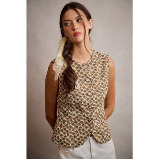 Woman wearing a sleeveless patterned top with a plain background