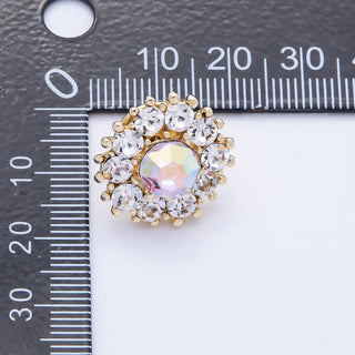 Gold and crystal brooch next to a ruler on a white background