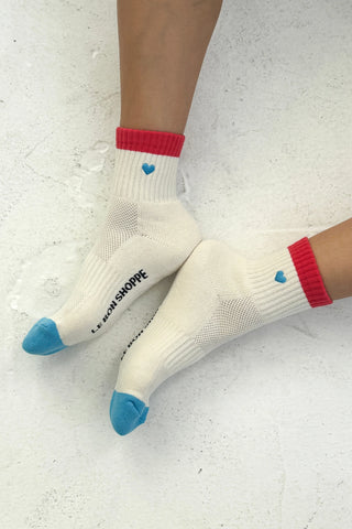 White socks with red cuffs and blue toes on a light gray background