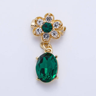 Gold brooch with green gemstones on a white background