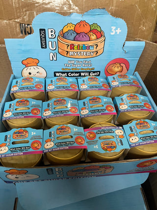 Display of 'Rainbow Mystery' toy packaging with colorful characters on a cardboard box.