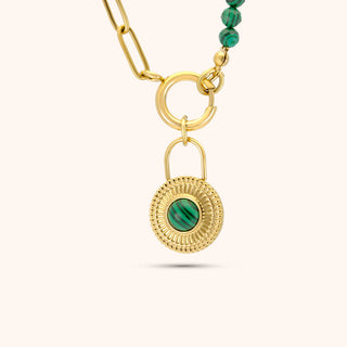 Gold necklace with a green gemstone pendant on a white background