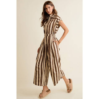 Woman wearing a brown and beige striped jumpsuit on a beige background