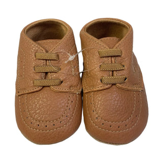 Pair of brown leather baby shoes on a white background