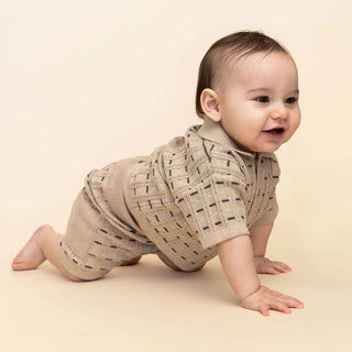 Baby wearing a beige knitted outfit on a beige background