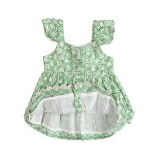 Green floral dress with white ruffles on a white background