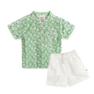 Green floral shirt and white shorts on a white background
