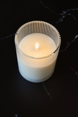 Candle in a glass holder on a dark surface