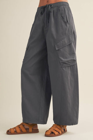 Gray cargo pants worn by a person on a beige background