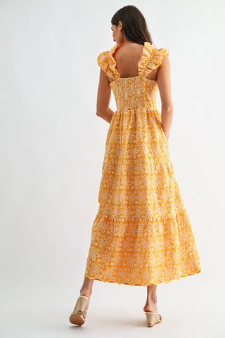 Woman wearing a yellow floral dress on a white background