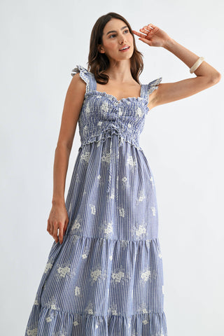 Woman wearing a blue floral dress against a white background