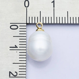 Pearl pendant with gold bail on a ruler for scale