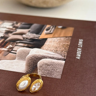 Gold earrings on a magazine with 'Amber Lewis' branding