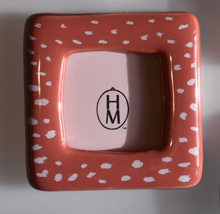 Ceramic frame with white pattern and 'H&M' logo on a plain background