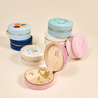 Set of colorful jewelry boxes with floral designs on a beige background