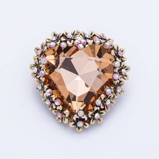 Heart-shaped gemstone with gold accents on a light gray background