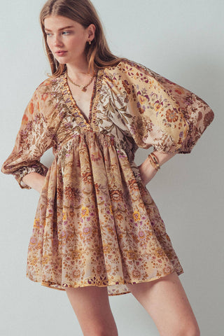 Woman wearing a floral dress against a plain background