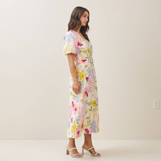 Woman wearing a floral dress against a plain background