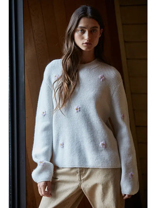 Girl wearing white sweater with pink flowers