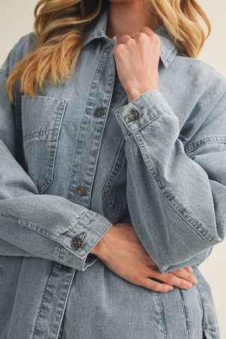 Close-up of a person wearing a light blue denim jacket.