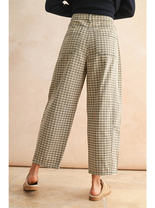 Person wearing plaid pants on a beige background